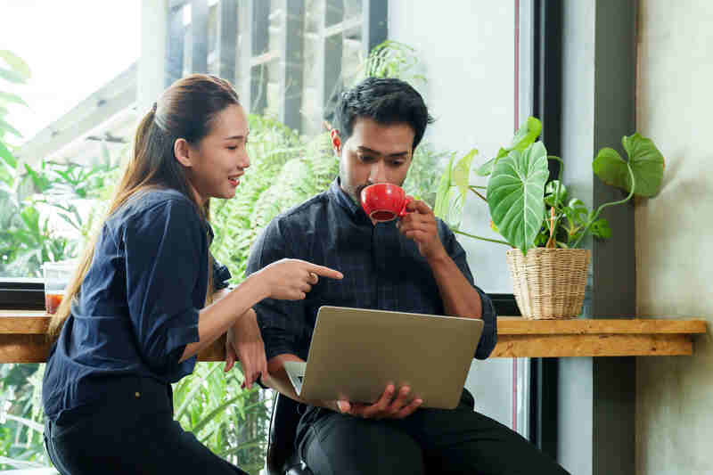 Small business cafe owners using laptop
