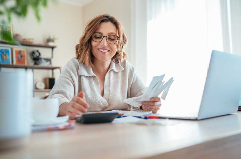 Female small business owner working with laptop and calculator accounting concept