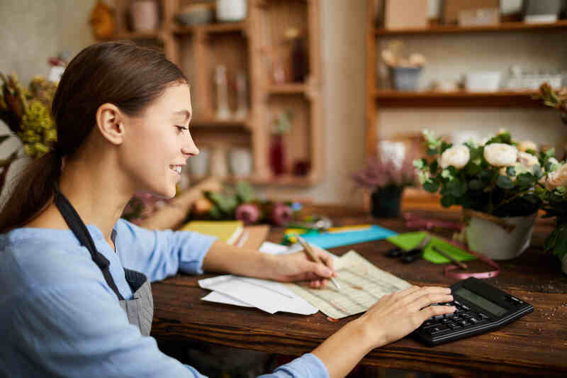 female businesswoman counting finances using calculator