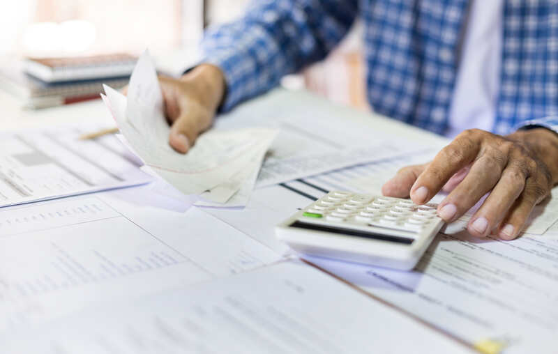 men using calculator to calculate customer acquisition costs
