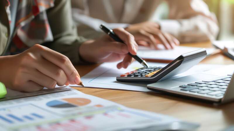 smalll business owners calculating finance with calculator