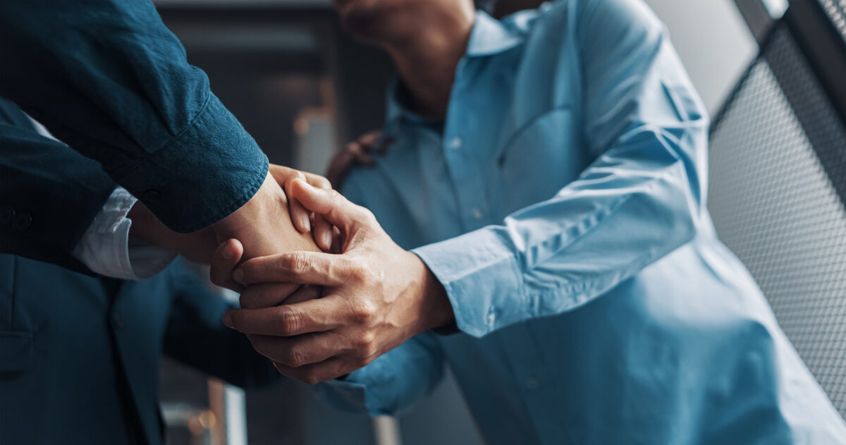 Two men in suits shaking hands.