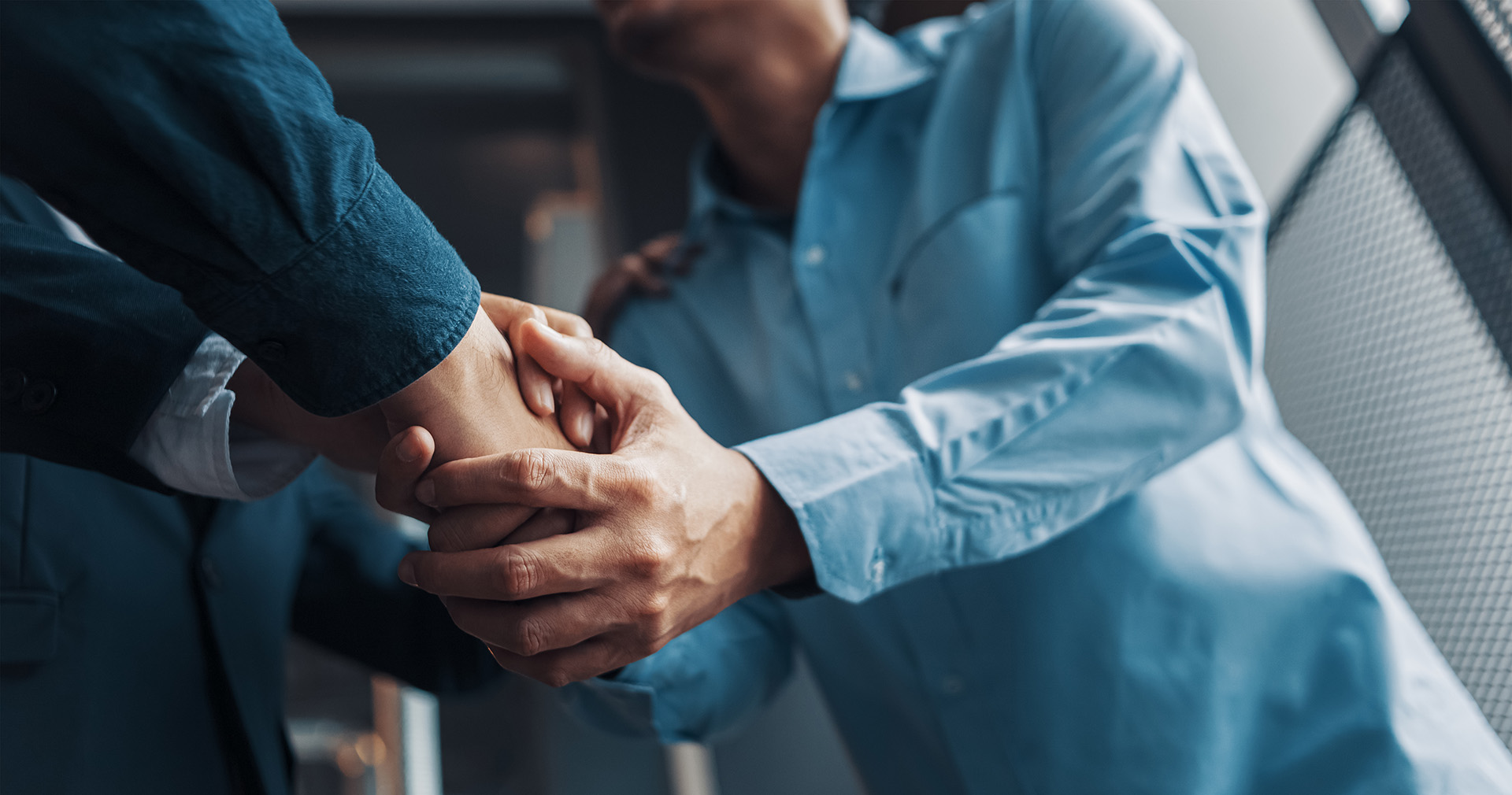 Two men in suits shaking hands.