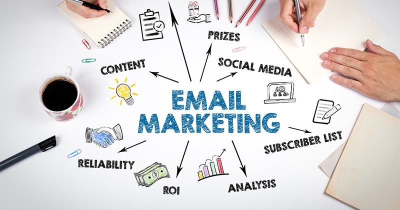 The words email marketing depicted in a drawn fashion onto a white table top. 