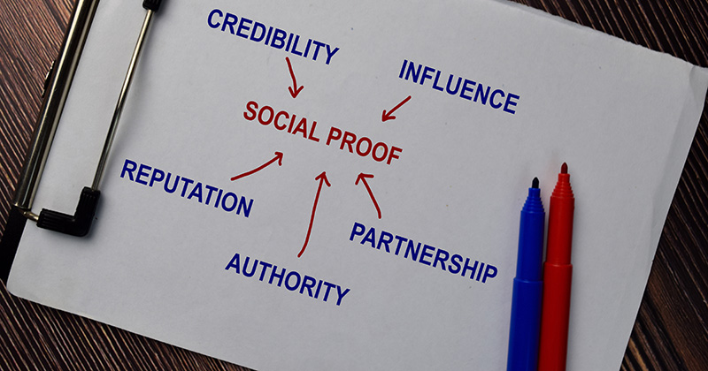 A paper on a clipboard with the word social proof written on it.