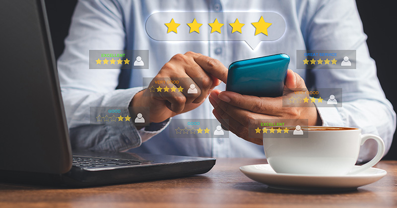 A man at a desk on a smartphone with an overlay of 5-star reviews.