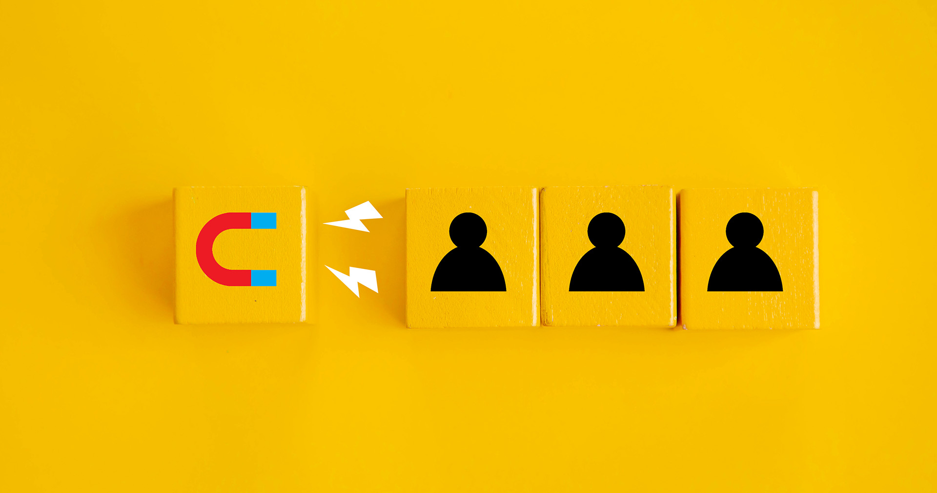 Graphics of a magnet attracting three blocks with person icons on them (representing customers) on a yellow background.