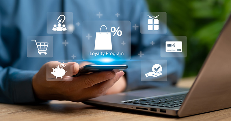 Person-holding-a-smartphone-with-a-graphic-displayed-over-it-showing-a-Loyalty-Program-with-a-shopping-bag-icon.